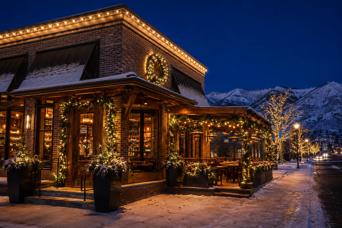 Heber City restaurant storefront with warm-white awning, window, patio, wreath, garland, and planter holiday lighting